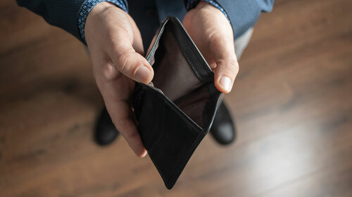 Well dressed man holding empty leather wallet. Financial crisis and bankruptcy concept