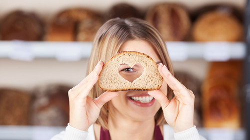 verkäuferin schaut durch ein brot mit herz