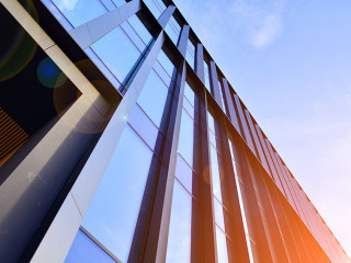 Glass modern building with blue sky background. Low angle view a