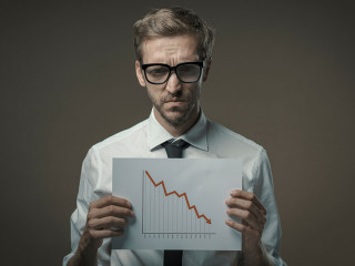 Businessman holding a negative financial chart