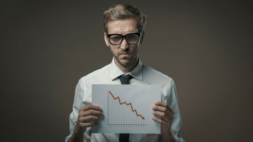 Businessman holding a negative financial chart