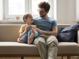 Happy loving dad hugging cute little daughter girl with tenderness