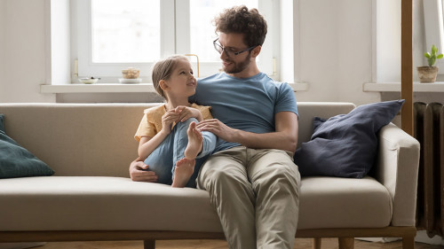 Happy loving dad hugging cute little daughter girl with tenderness