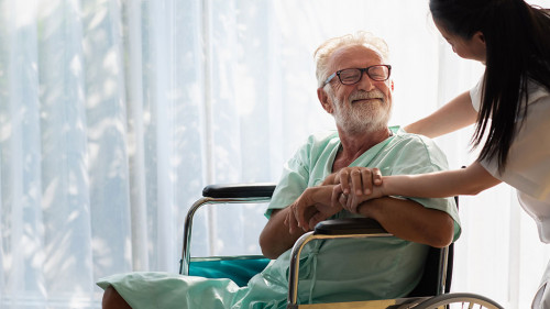 Eldery in wheelchair with nurse. An old man in a hospital, a nur