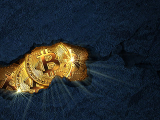 Golden bitcoins inside a rock cracked open