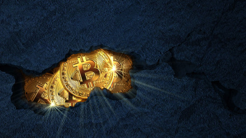 Golden bitcoins inside a rock cracked open