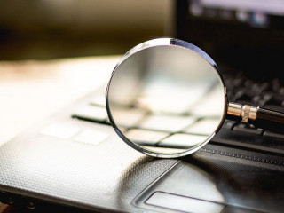 Magnifying glass is located on the keyboard. Of computer noteboo