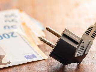 Electric plug and euro money on wooden table. Concept of increasing electric prices.