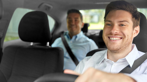 male taxi driver driving car with passenger