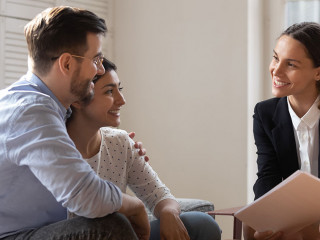 Client and banker seated on sofa discuss mortgage contract terms