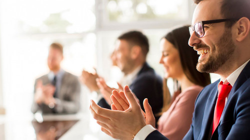 Smiling business group clapping hands at the meeting