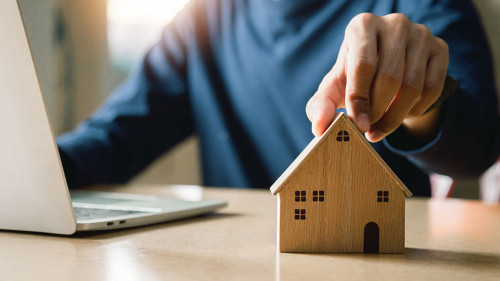 Business hand holding home with Buy or Rent, copy space. Propert