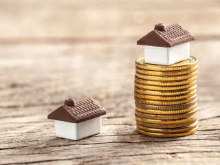 House and a stack of coins. The market price of the house. Real