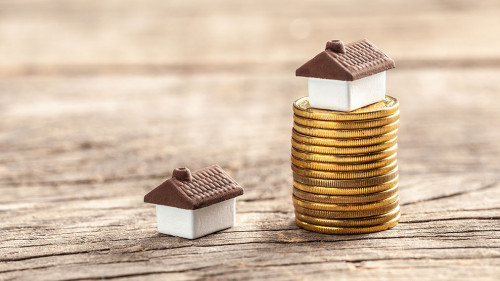 House and a stack of coins. The market price of the house. Real