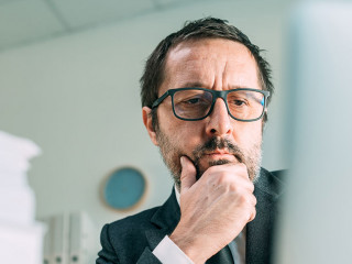 Panoramic portrait of worried businessman looking at laptop in b