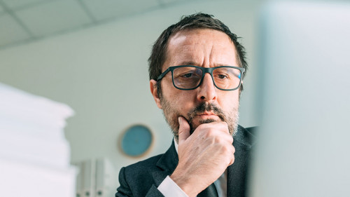 Panoramic portrait of worried businessman looking at laptop in b
