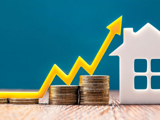 Real estate market, graph, up arrow. House model and a stack of coins. The concept of inflation, economic growth, the price of insurance services