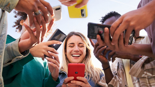 Low angle view of a group of young teenagers using cell phones. Concept of technology, connection.