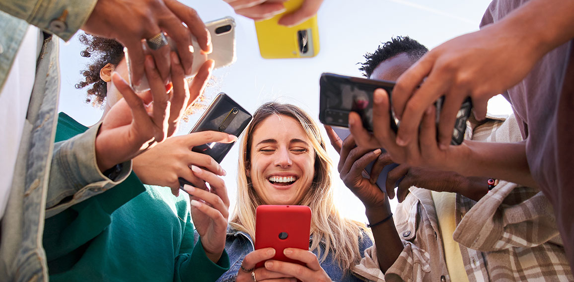 Low angle view of a group of young teenagers using cell phones. Concept of technology, connection.