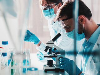 Doctor in the laboratory analyzes samples of codiv-9 under a microscope