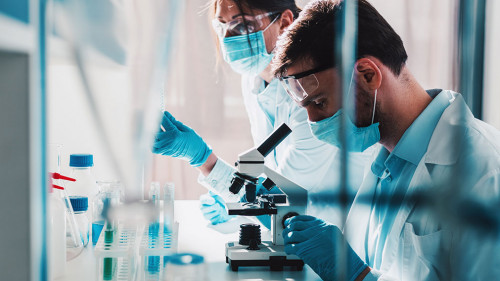 Doctor in the laboratory analyzes samples of codiv-9 under a microscope