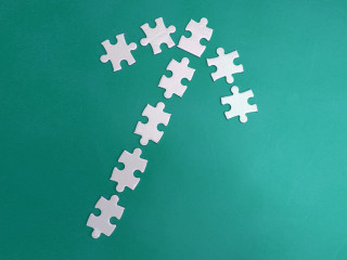White puzzles arranged according to the shape of arrows on a red