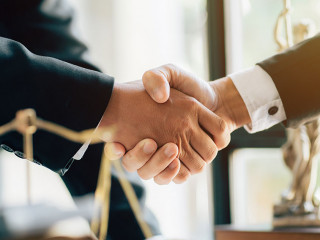 Businessman shaking hands to seal a deal with his partner lawyer