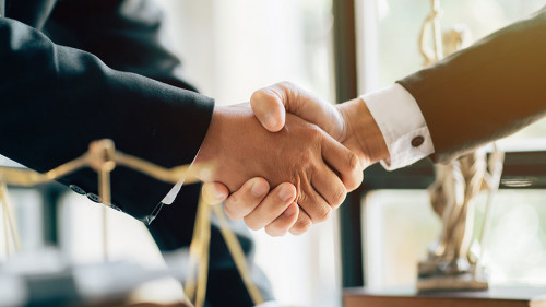 Businessman shaking hands to seal a deal with his partner lawyer