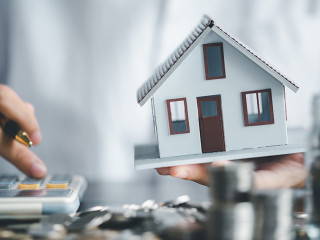 Saving investment home with loan finance money business concept. Investment banking finance for residential real estate business. Stack coins with model house for investment loans.Cash for taxes.