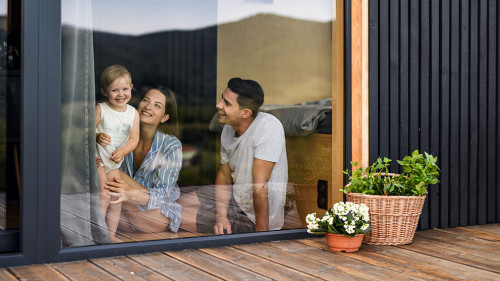 Young family with small daughter indoors, weekend away in container house in countryside.