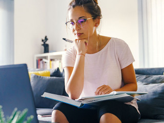Front view on young caucasian woman study in front of the laptop