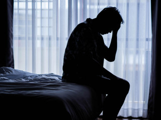 Lonely man silhouette sitting on the bed feeling depressed and s