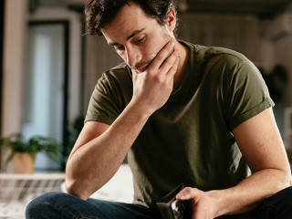 Young man checking empty wallet, no money. Unemployed sad man si