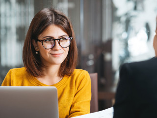 Group of happy business people have meeting at workplace in office. Two positive woman working together using modern laptop for working concept