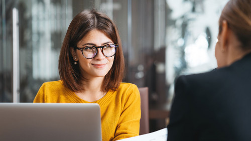 Group of happy business people have meeting at workplace in office. Two positive woman working together using modern laptop for working concept