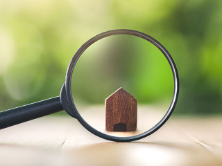 Wooden houses and magnifying glass. Property valuation. Home app