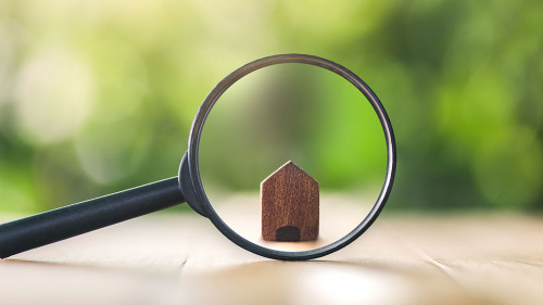 Wooden houses and magnifying glass. Property valuation. Home app