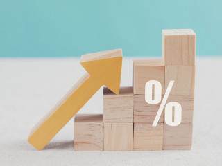 Wooden blocks with big percentage sign and arrow up, financial g