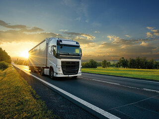 White truck driving on the asphalt road in rural landscape in th