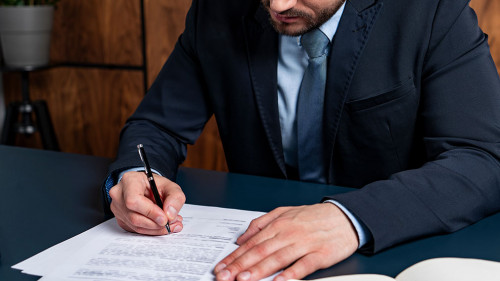 A good looking man signing the mortgage contract at the real property agent office. The concept of entering into legal power to take liabilities. Real eastate.