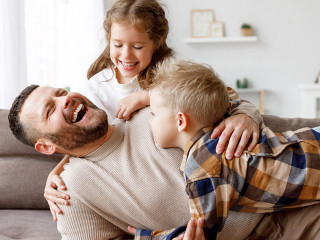 Kids playing with father on sofa
