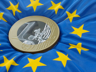Euromünze auf Europaflagge