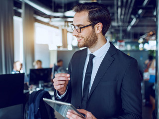 Handsome caucasian bearded smiling businessman in suit and with
