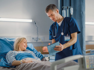 Hospital Ward: Friendly Male Nurse Talks to Beautiful Female Pat