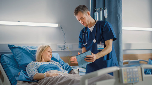 Hospital Ward: Friendly Male Nurse Talks to Beautiful Female Pat