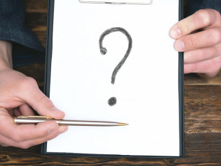 A question mark in a business document in a businessman hands.