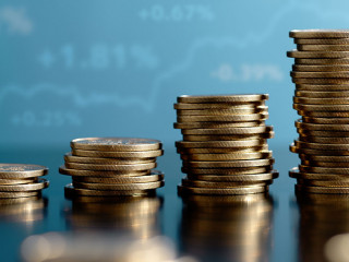 Investment and asset management yield. Stacked coins and graph.