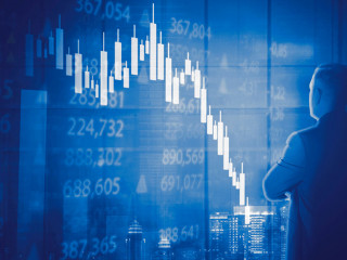 Male manager looking at declining candlestick chart