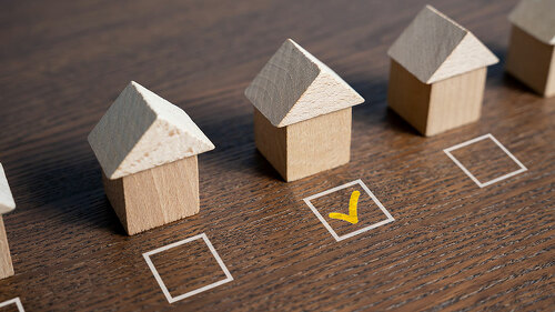 House selection. The selected house is checked with a tick. Checkbox. Difficulty of finding the perfect home. Searching for a new home. Mark the preferred choice. Real estate market offers overview.