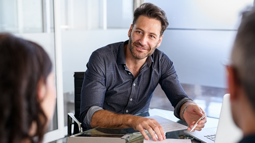 Confident businessman advising couple on finance